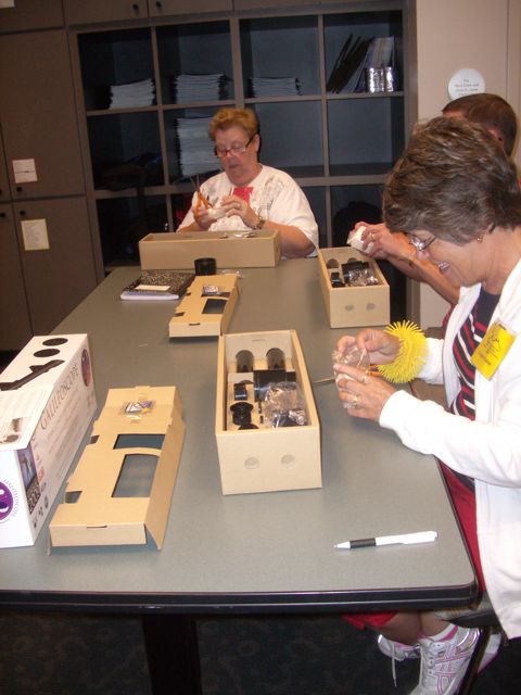 Linda Broome and Louann Fisher look over the Galileoscope parts