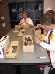Linda Broome and Louann Fisher look over the Galileoscope parts